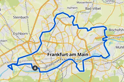 Eine Karte hebt Frankfurt am Main in Deutschland hervor, wobei ein dicker blauer Umriss die Grenzen der Stadt markiert. Zu den umliegenden Städten zählen Eschborn, Steinbach, Bad Vilbel und Bischofsheim. Verschiedene Straßen und Eisenbahnlinien verlaufen kreuz und quer durch die Stadt und ihre Außenbezirke.